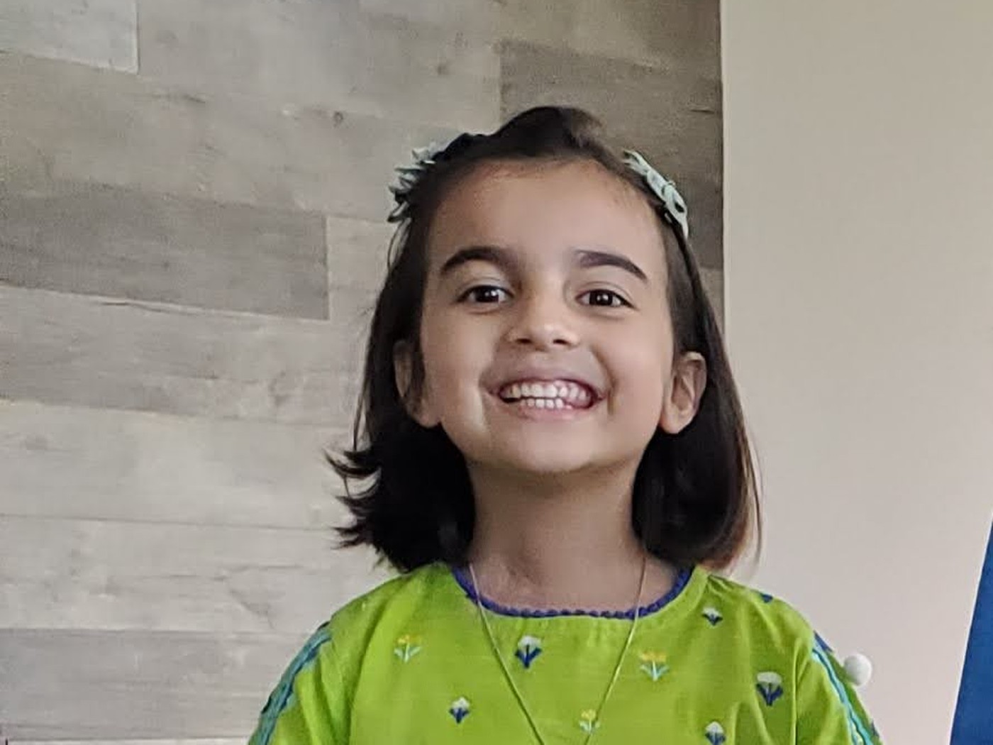 Minaal smiling in a green outfit